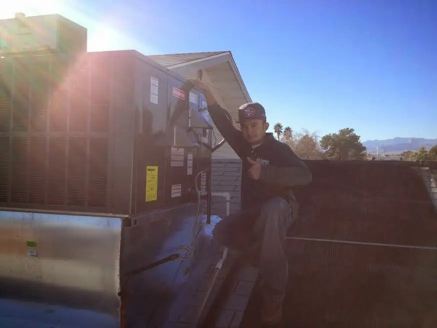 HVAC technician performing HVAC Inspection on a rooftop unit in Grand Forks